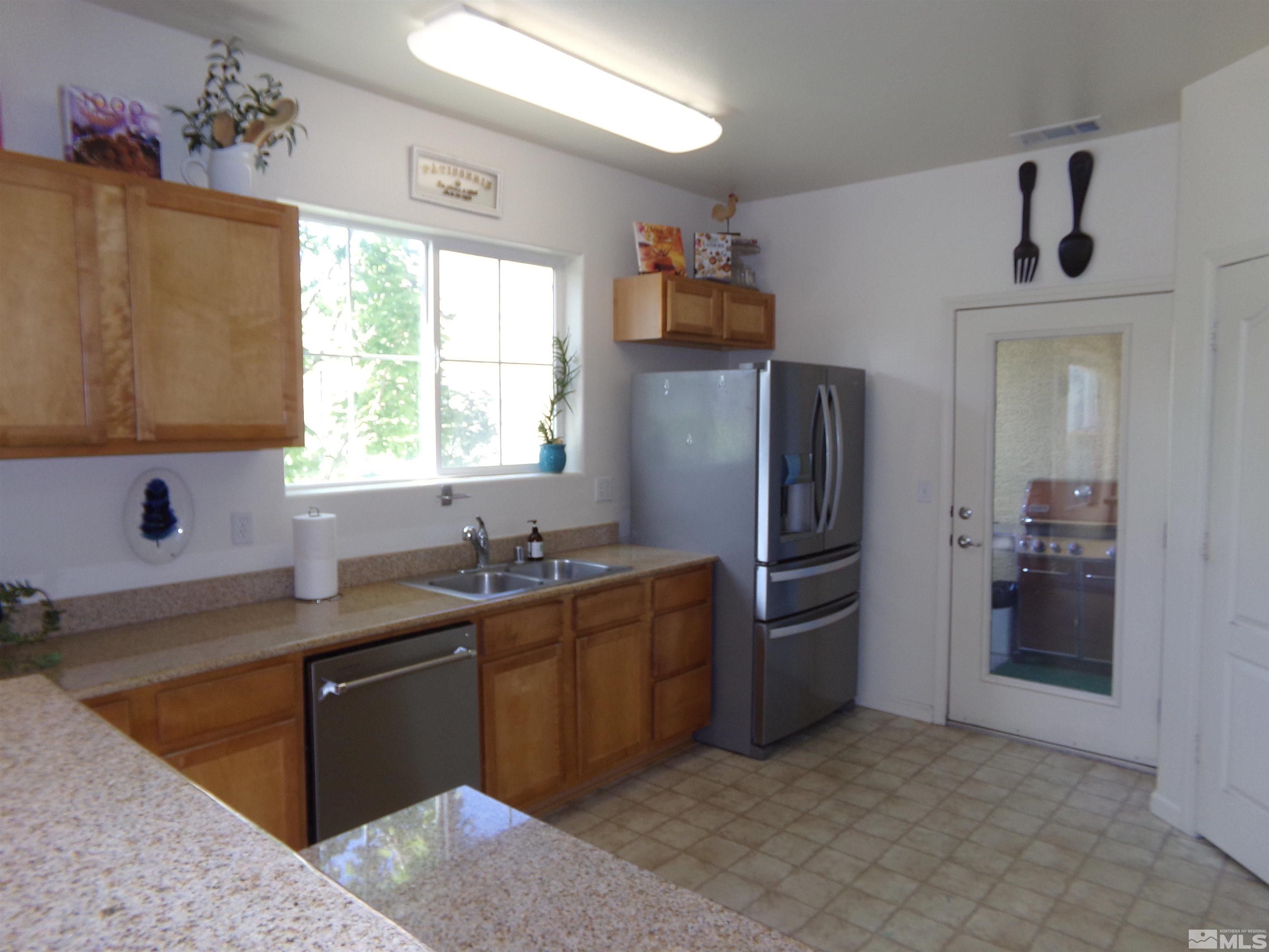 9050 Double R Boulevard, Unit 1124 Reno, NV 89521 - Photo 4 of 40 a kitchen with stainless steel appliances granite countertop a refrigerator and a sink