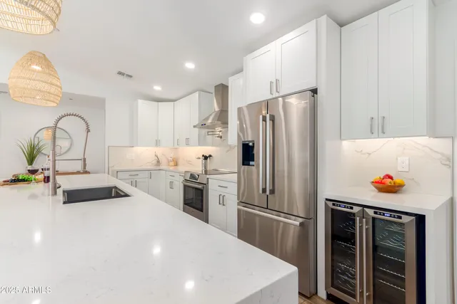 a kitchen with stainless steel appliances a refrigerator sink and white cabinets