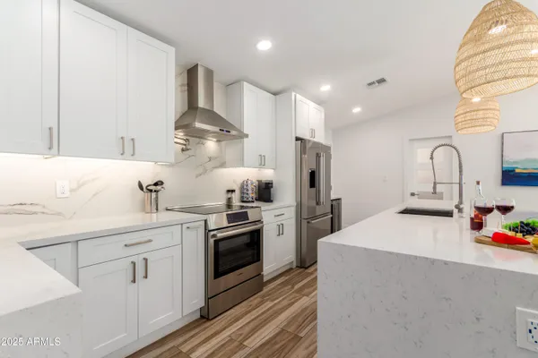 a kitchen with stainless steel appliances a sink stove and refrigerator