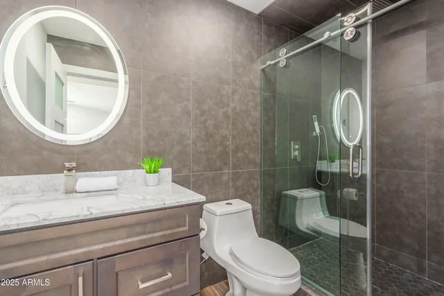 a bathroom with a granite countertop sink mirror vanity and toilet