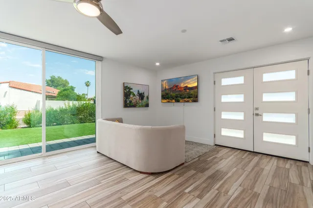 a living room with a couch wooden floor and windows