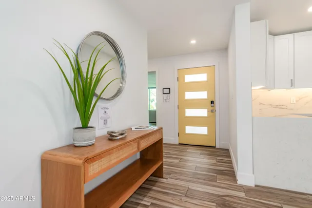 a bathroom with a sink a mirror and a potted plant