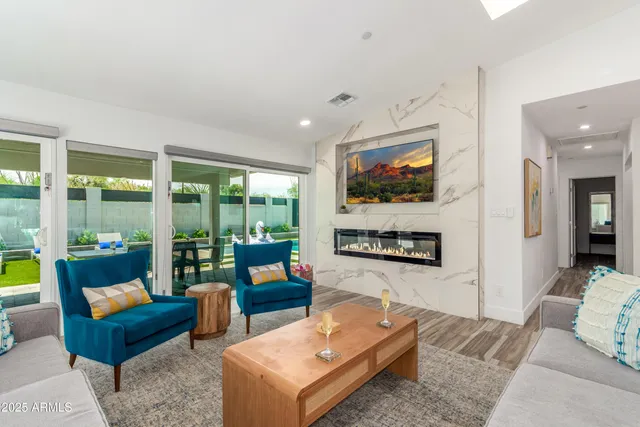a living room with furniture a floor to ceiling window and a flat screen tv