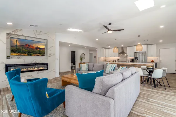 a living room with furniture kitchen view and a flat screen tv