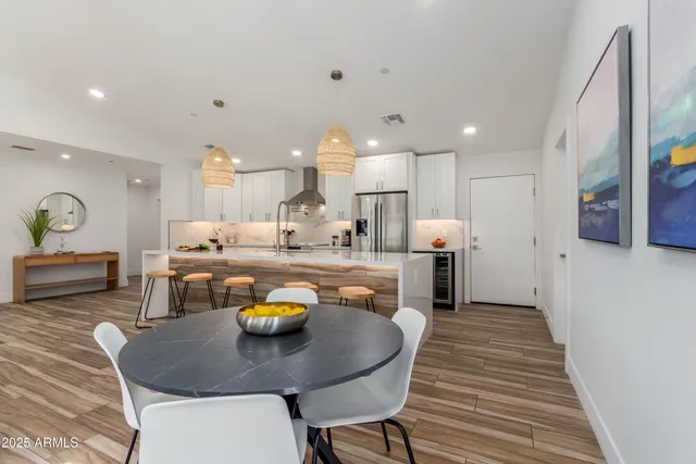 a kitchen with a dining table chairs wooden floor and a kitchen view