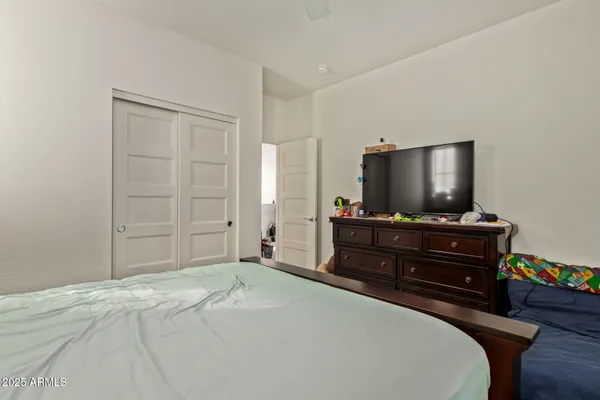 a bedroom with a bed and a flat screen tv