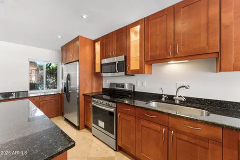 a kitchen with stainless steel appliances granite countertop a sink refrigerator and microwave