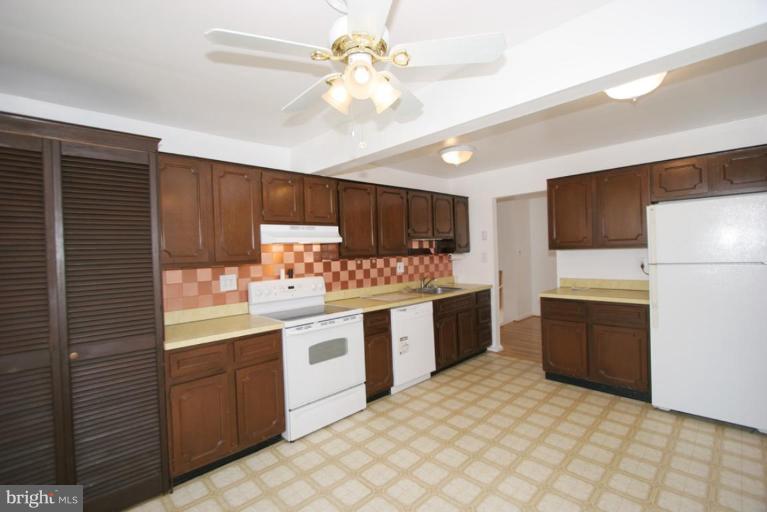 3520 Olympic Street Silver Spring, MD 20906 - Photo 18 of 24 a kitchen with granite countertop a sink stainless steel appliances and counter space