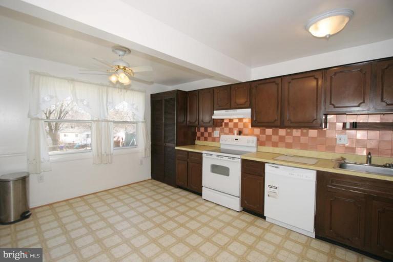 3520 Olympic Street Silver Spring, MD 20906 - Photo 19 of 24 a kitchen with granite countertop a sink cabinets stainless steel appliances and a window