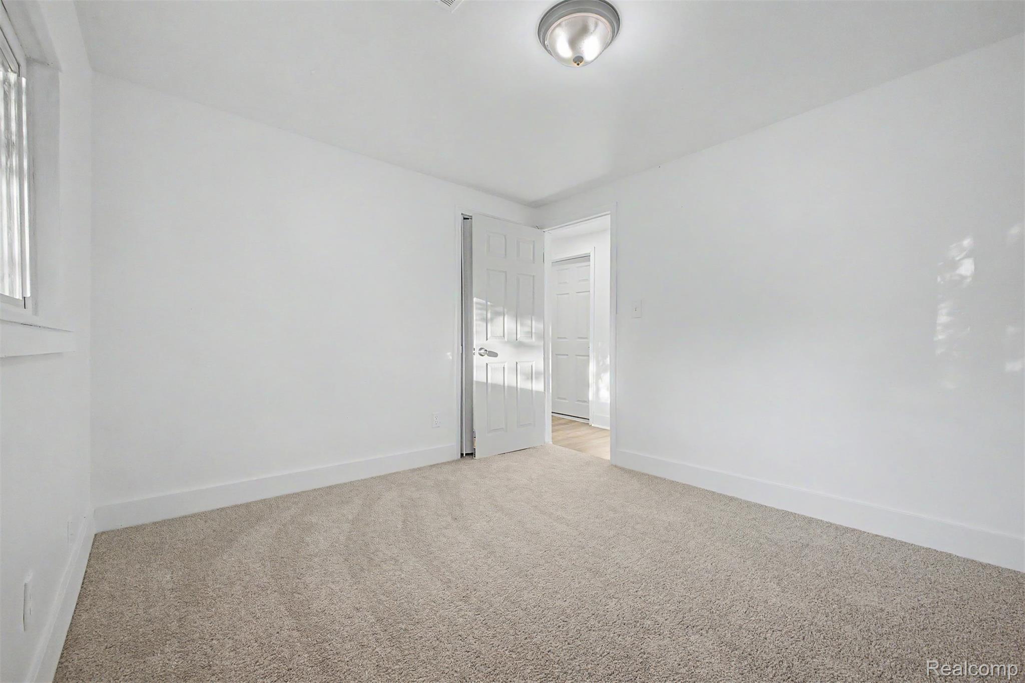 26718 Penn Street Inkster, MI 48141 - Photo 23 of 27 Carpeted room featuring white walls, a flush-mount ceiling light, white trim, and a window with vertical blinds