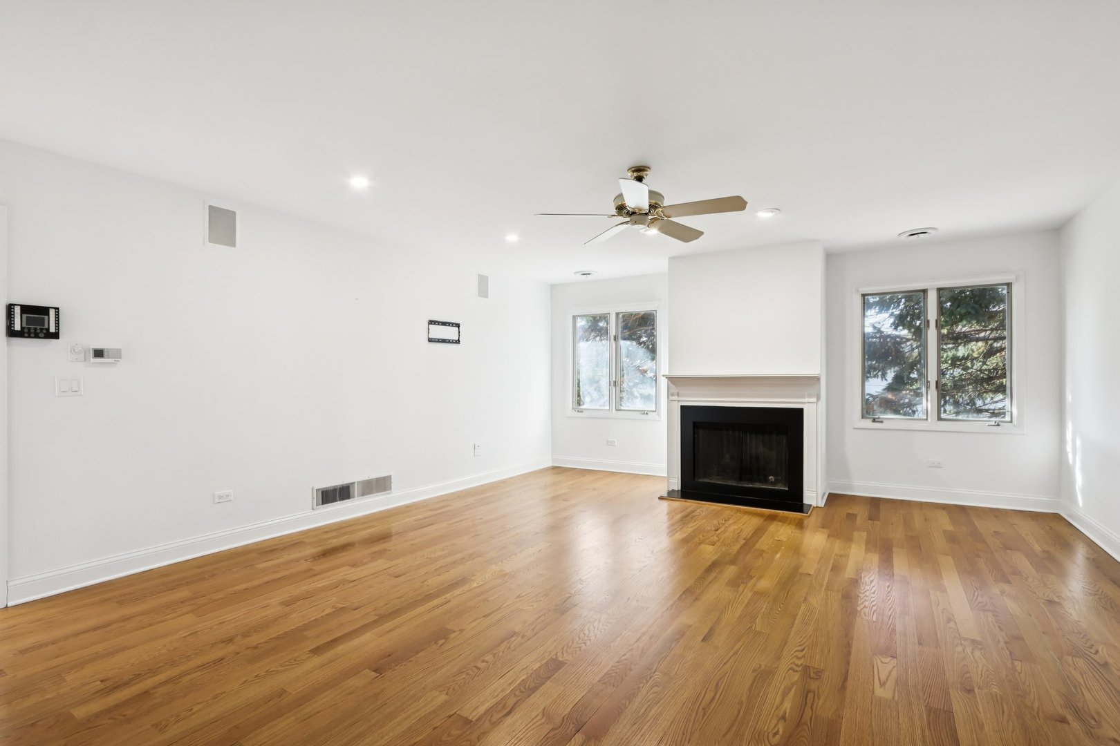 2019 East Avon Lane Arlington Heights, IL 60004 - Photo 31 of 58 an empty room with wooden floor a fireplace and windows