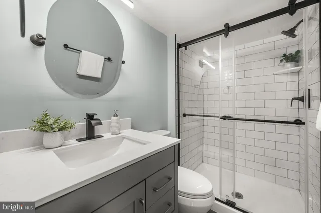 a bathroom with a sink toilet a mirror and shower