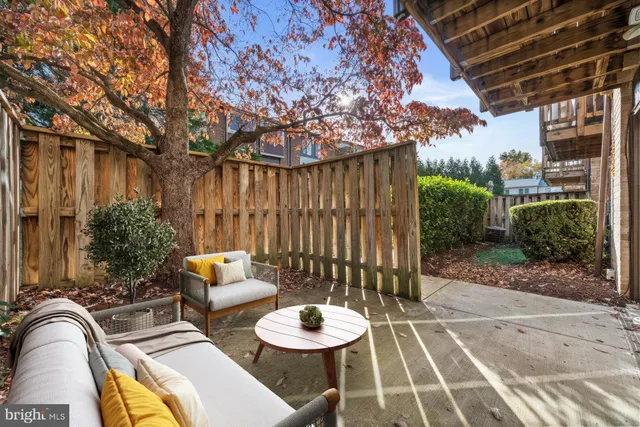 a backyard of a house with fountain table and chairs