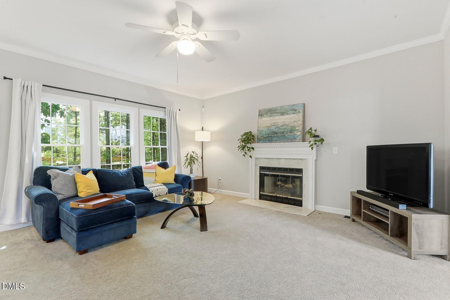 4001 Batiste Road Raleigh, NC 27613 - Photo 12 of 63 a living room with furniture a fireplace and a flat screen tv