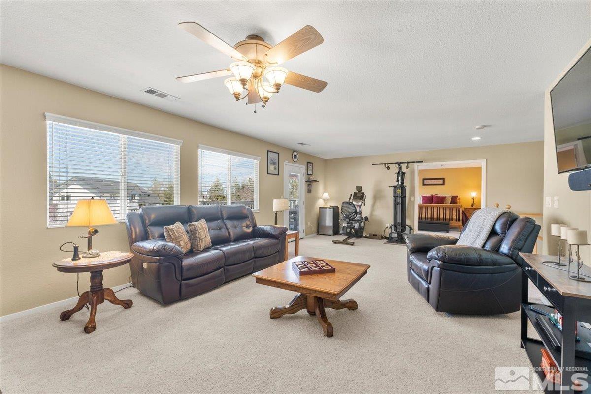 2225 Solitude Drive Reno, NV 89511 - Photo 16 of 40 a living room with furniture a rug and a chandelier