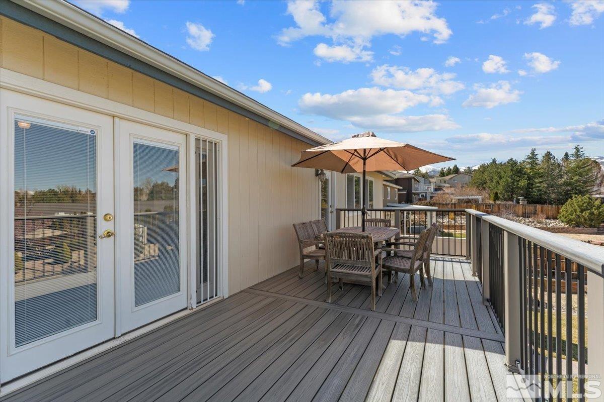 2225 Solitude Drive Reno, NV 89511 - Photo 23 of 40 a view of a roof deck with table and chairs with wooden floor and fence