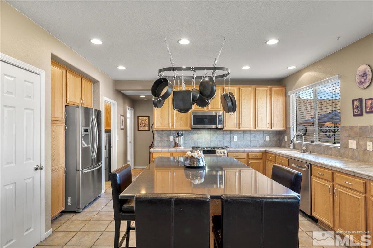 2225 Solitude Drive Reno, NV 89511 - Photo 8 of 40 a kitchen with stainless steel appliances granite countertop a sink a stove a refrigerator and island