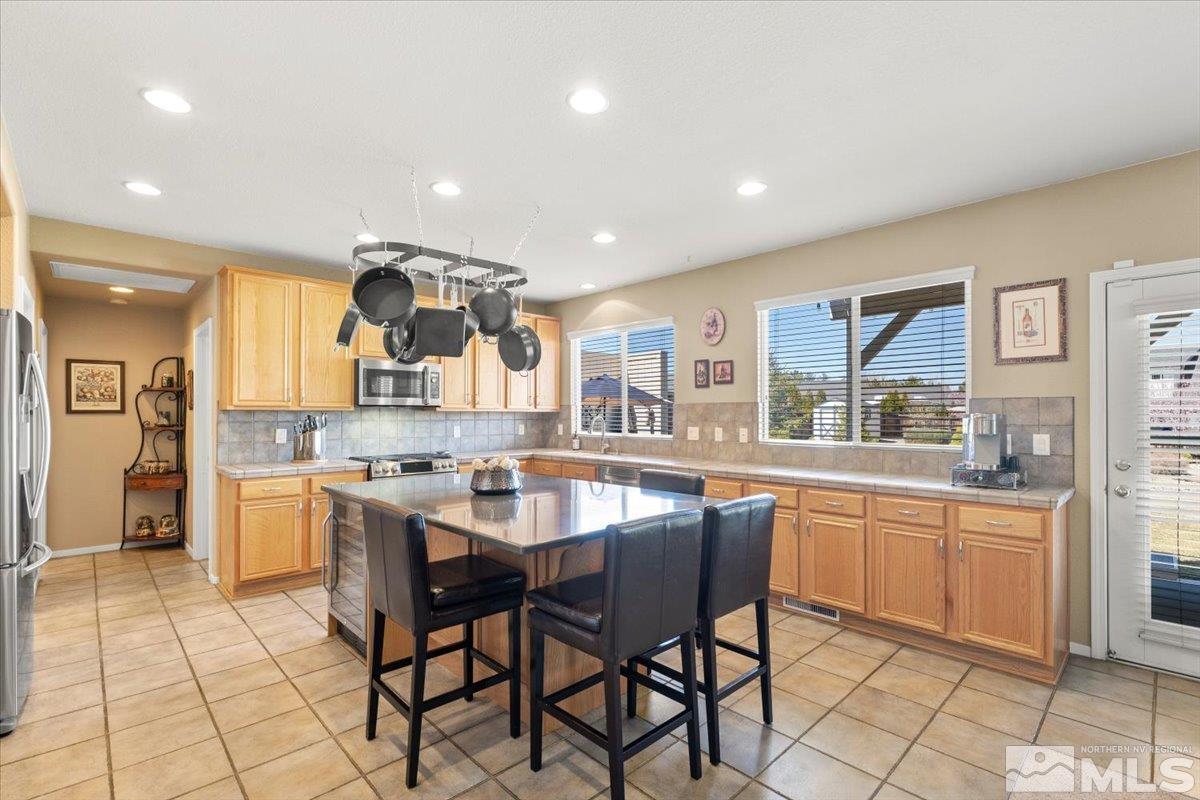 2225 Solitude Drive Reno, NV 89511 - Photo 9 of 40 a kitchen with stainless steel appliances granite countertop a sink and a refrigerator