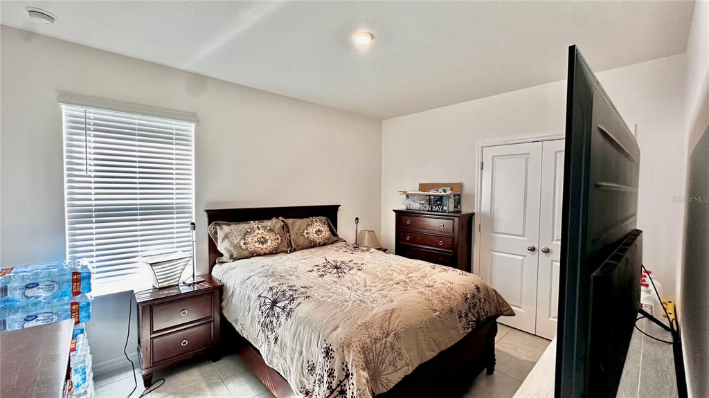 6623 Lullaby Way Mascotte, FL 34753 - Photo 11 of 24 a bedroom with a bed and a television