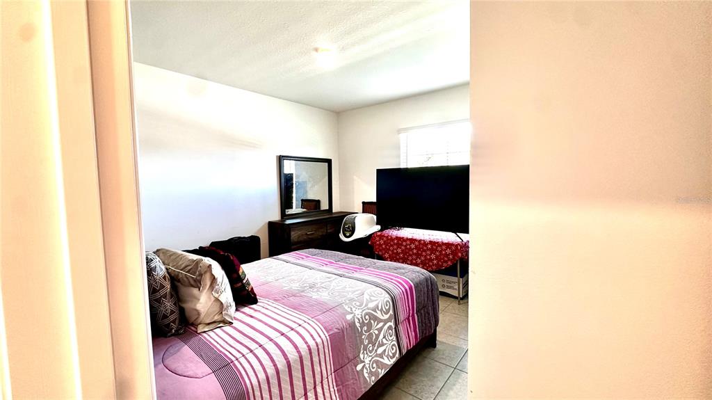 6623 Lullaby Way Mascotte, FL 34753 - Photo 12 of 24 a bedroom with a bed and a flat screen tv