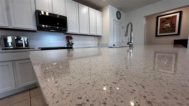 a view of a refrigerator in kitchen and an empty room