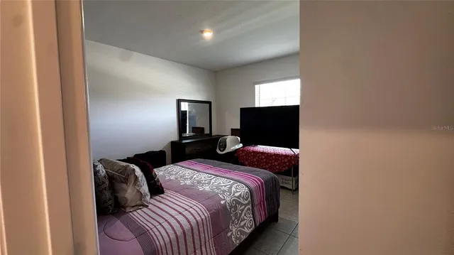 a bedroom with a bed and a flat screen tv