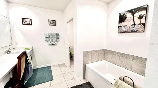 a bathroom with a tub a sink and glass door
