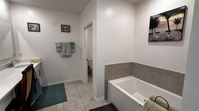 a bathroom with a tub a sink and mirror