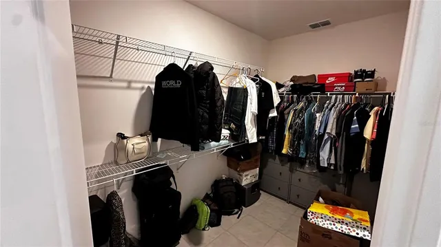 a view of walk in closet with clothes and shoes