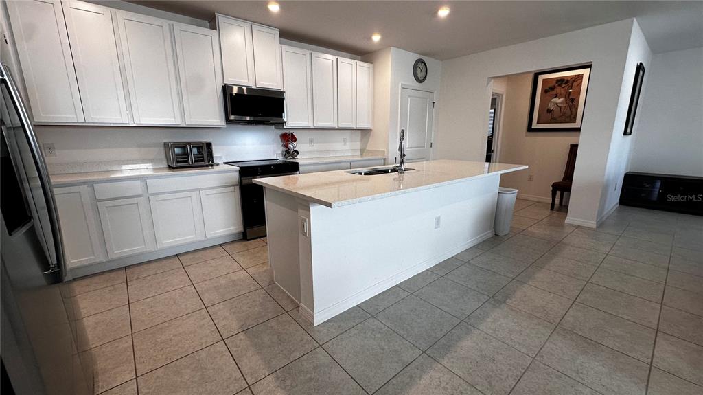6623 Lullaby Way Mascotte, FL 34753 - Photo 6 of 24 a kitchen with a sink a stove and cabinets