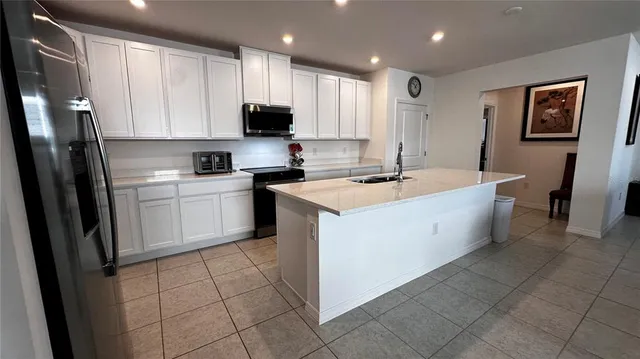 a kitchen with a sink a stove a refrigerator a microwave oven and cabinets