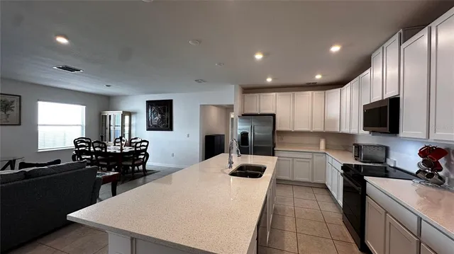 a kitchen with refrigerator and chairs