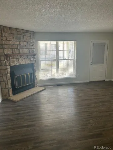 wooden floor fireplace and windows in an empty room