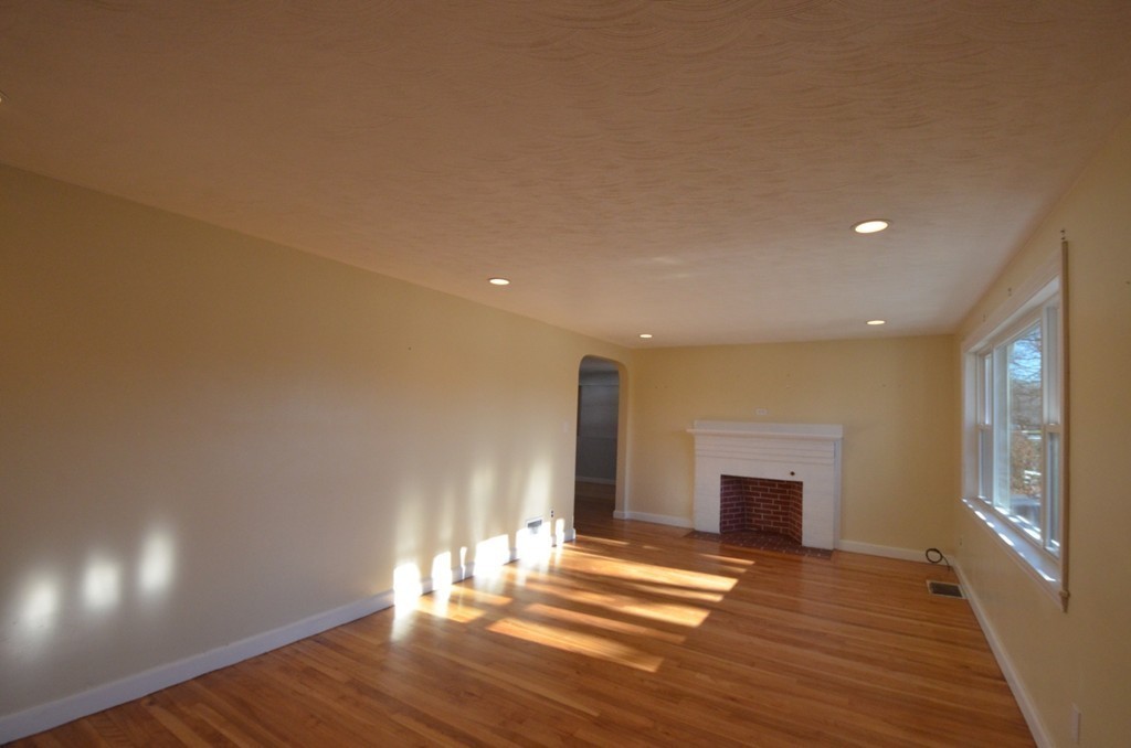 1239 Trapelo Road Waltham, MA 02451 - Photo 11 of 20 a view of empty room with wooden floor and fireplace
