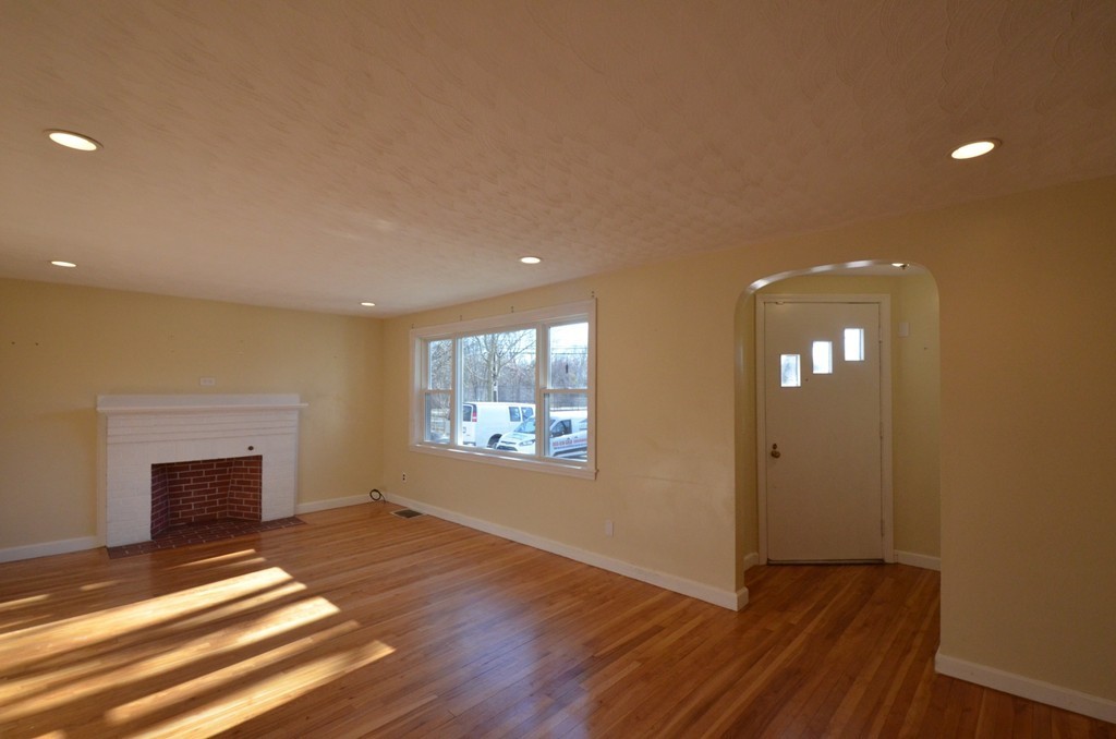 1239 Trapelo Road Waltham, MA 02451 - Photo 10 of 20 a view of empty room with wooden floor and fireplace