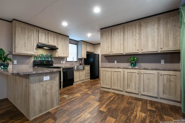 a kitchen with granite countertop a stove top oven sink and cabinets