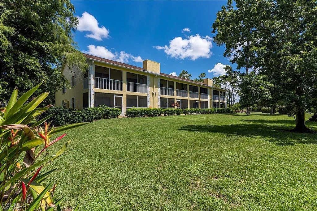 2780 Kings Lake Boulevard, Unit 203 Naples, FL 34112 - Photo 22 of 22 a view of a house with a big yard and large trees