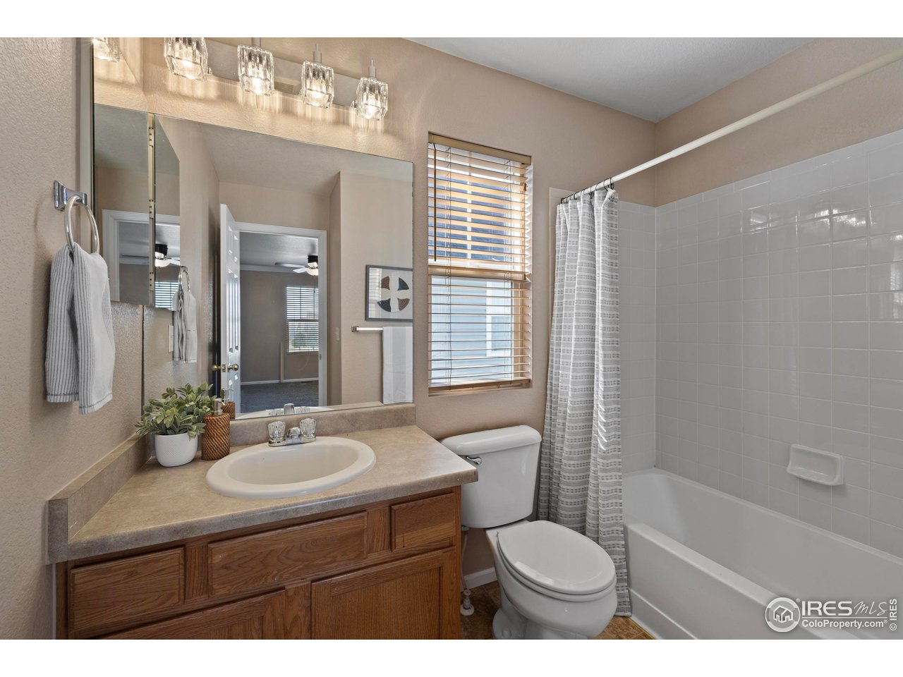 7399 Russell Circle Frederick, CO 80504 - Photo 21 of 35 a bathroom with a sink toilet a mirror and shower