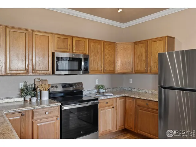 a kitchen with a sink a microwave a refrigerator and cabinets