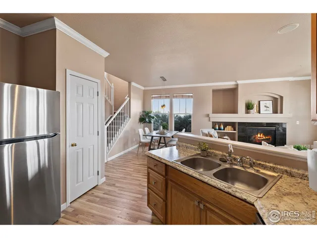 a kitchen with a sink a refrigerator and a stove with wooden floor