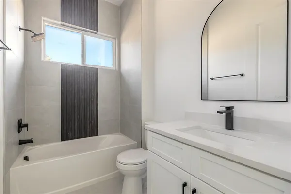 a kitchen with stainless steel appliances a refrigerator a stove a sink and white cabinets