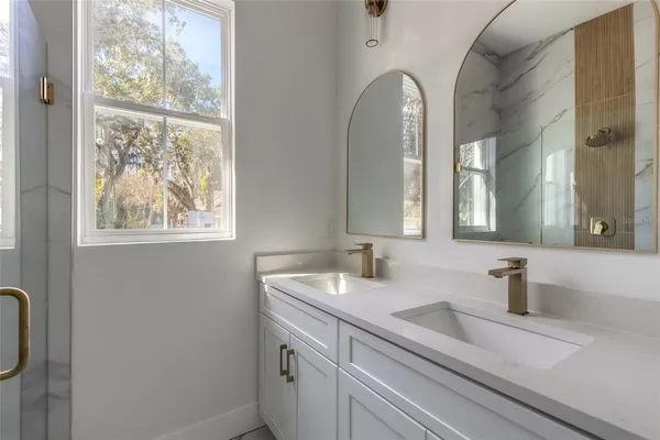 a white kitchen with stainless steel appliances granite countertop a sink a stove a refrigerator a washer and dryer