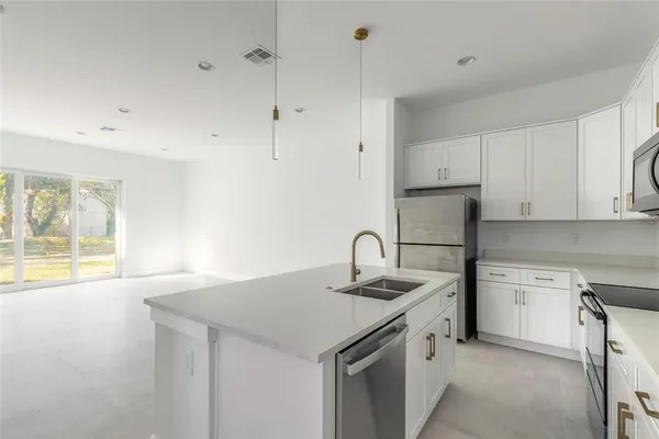a kitchen with stainless steel appliances granite countertop a sink a stove and a refrigerator