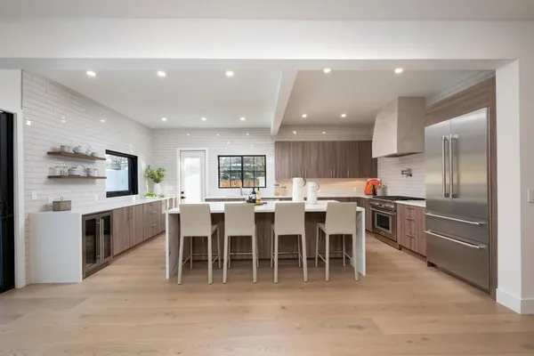 a large kitchen with lots of counter space dining table and stainless steel appliances
