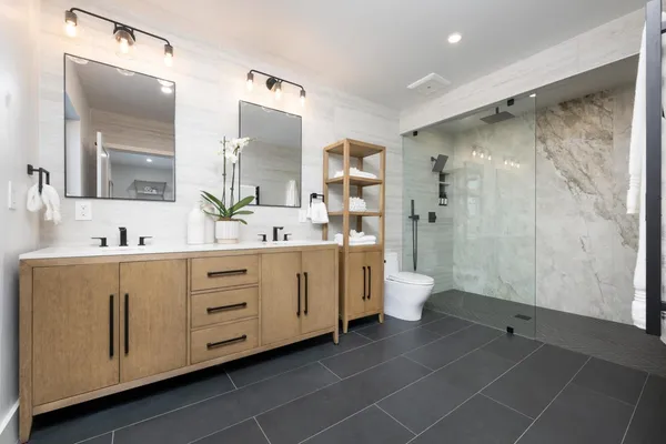 a spacious bathroom with a double vanity sink toilet and shower