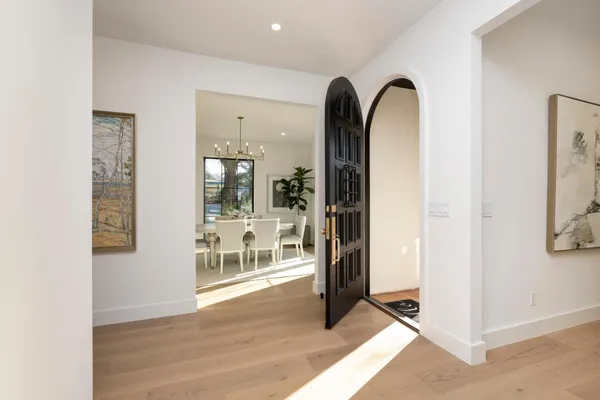 a view of an entryway with wooden floor and a livingroom