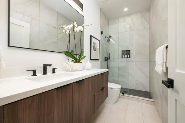 a bathroom with a double vanity sink toilet and shower