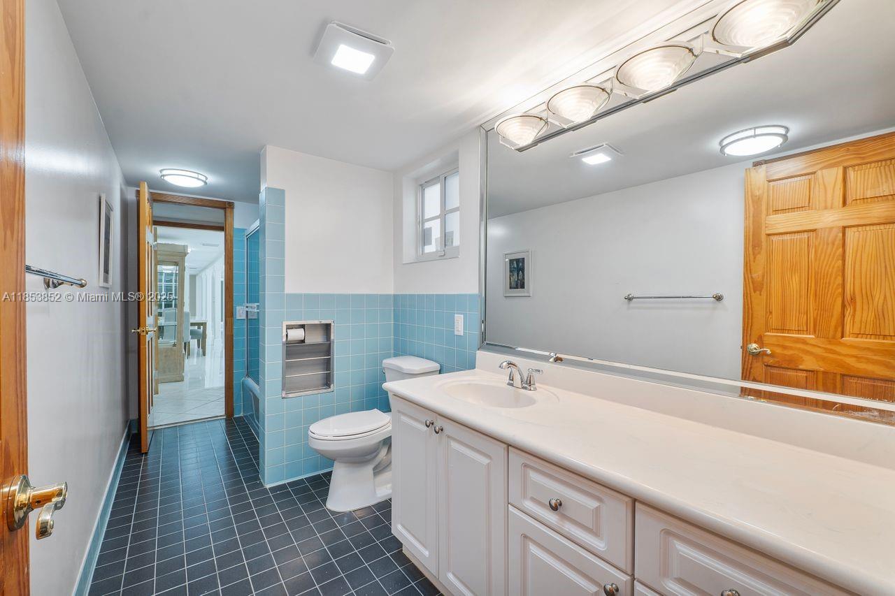 13000 Old Cutler Road Pinecrest, FL 33156 - Photo 12 of 43 a bathroom with a sink a toilet a large mirror and shower