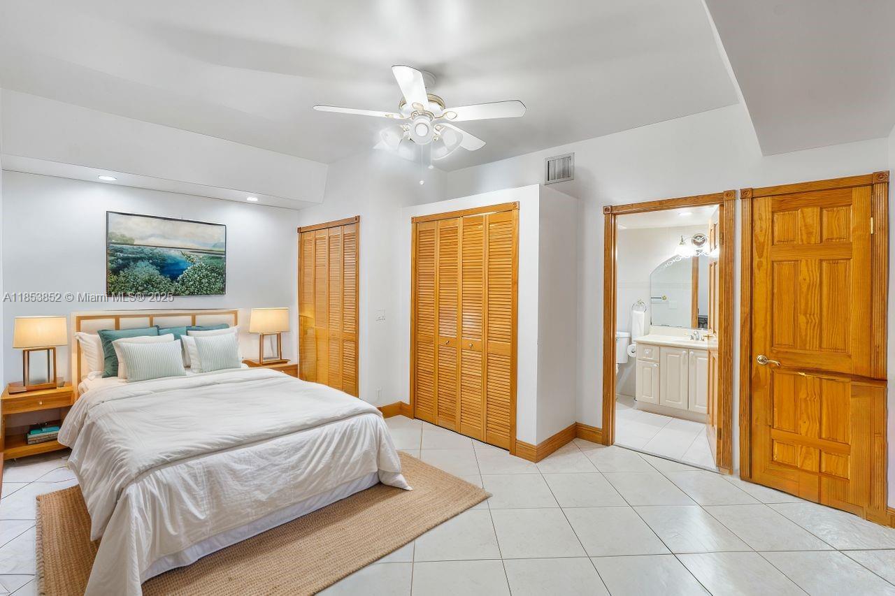 13000 Old Cutler Road Pinecrest, FL 33156 - Photo 14 of 43 a bedroom with a large bed and a chandelier