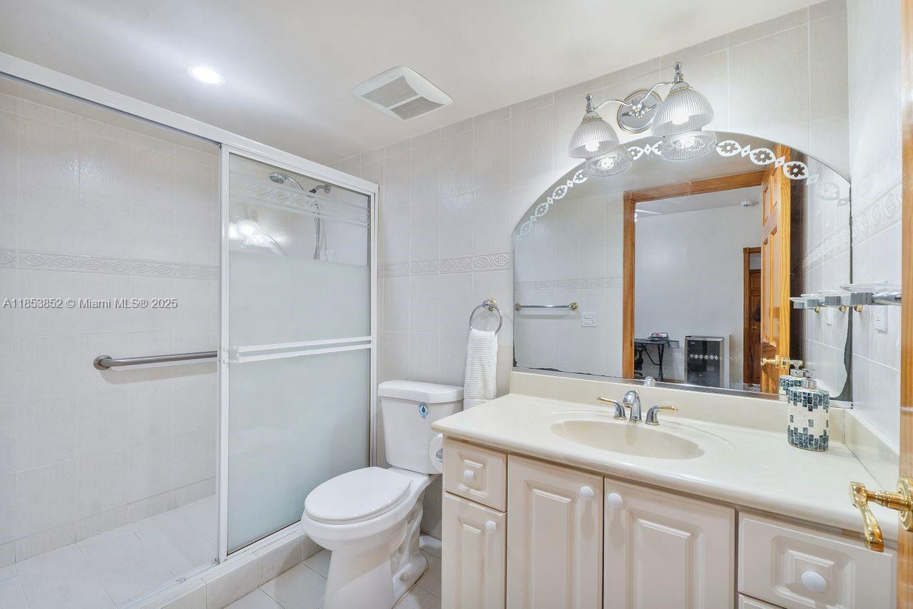 13000 Old Cutler Road Pinecrest, FL 33156 - Photo 15 of 43 a bathroom with a toilet sink and mirror